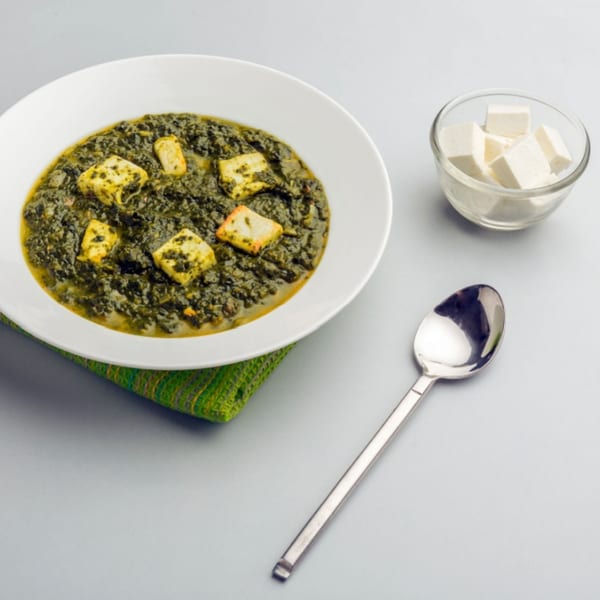 Himalayan Spice Indian Cuisine's Palak Paneer, a vibrant green spinach curry with paneer cheese cubes.
