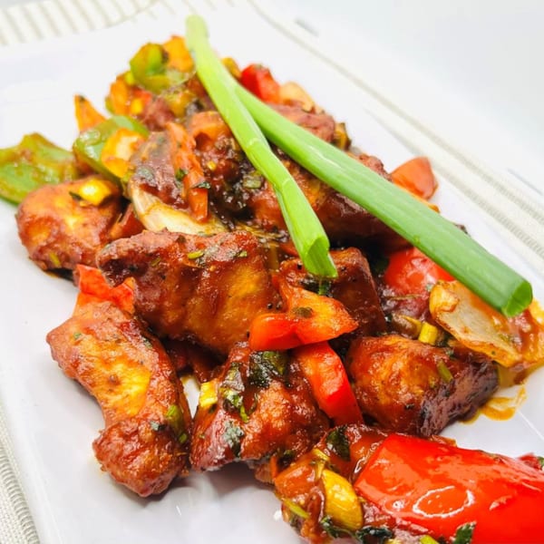 Himalayan Spice Indian Cuisine's chili chicken, featuring crispy chicken pieces with bell peppers and onions.